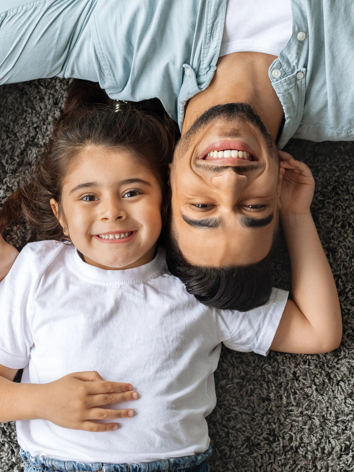 Father and daughter lying on a soft carpet